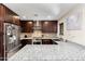 Modern kitchen with granite countertops, stainless steel appliances, and dark wood cabinetry at 2525 E Nisbet Rd, Phoenix, AZ 85032