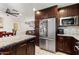 Modern kitchen with a stainless steel fridge, granite counters, and dark wood cabinets at 2525 E Nisbet Rd, Phoenix, AZ 85032