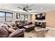 Cozy living room featuring comfortable leather seating, large windows, and a ceiling fan at 2525 E Nisbet Rd, Phoenix, AZ 85032