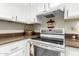 Bright kitchen featuring white cabinets and granite countertops around a flat-top stove at 26681 S Howard Dr, Sun Lakes, AZ 85248