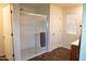 This bathroom features a glass shower, neutral paint, a window, and wood-look flooring at 27 N 199Th Ave, Buckeye, AZ 85326