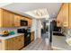 Functional kitchen featuring light wood cabinets, black appliances, and a skylight at 301 E Carol Ann Way, Phoenix, AZ 85022