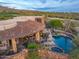 Expansive aerial view of a luxury home with a tile roof, outdoor kitchen, pool and spa, nestled in the desert landscape at 41731 N Stone Cutter Dr, Scottsdale, AZ 85262