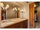 Bathroom with double sinks, stone countertops, rustic wood cabinetry, and stylish lighting at 41731 N Stone Cutter Dr, Scottsdale, AZ 85262