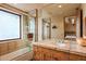 Bathroom featuring a tiled shower and tub combination, with a warm color palette and bright window at 41731 N Stone Cutter Dr, Scottsdale, AZ 85262