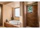 Bright bathroom featuring a soaking tub, a tiled shower, and warm earth tones at 41731 N Stone Cutter Dr, Scottsdale, AZ 85262