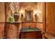 Charming powder room featuring unique tiling, decor, and a rustic wooden door at 41731 N Stone Cutter Dr, Scottsdale, AZ 85262