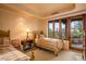 This bedroom features two beds, a window with views, and wood doors leading to a patio at 41731 N Stone Cutter Dr, Scottsdale, AZ 85262