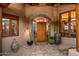 Exterior front door with decorative tiled archway and desert landscaping at 41731 N Stone Cutter Dr, Scottsdale, AZ 85262