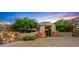 Exterior front entrance with stone wall, brick driveway, trees and desert landscape at 41731 N Stone Cutter Dr, Scottsdale, AZ 85262