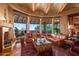 Spacious living room featuring beamed ceilings, fireplace and expansive windows showcasing stunning views at 41731 N Stone Cutter Dr, Scottsdale, AZ 85262