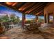 Spacious covered patio with stone pillars, a dining area, comfortable seating, and a pool, perfect for outdoor entertaining at 41731 N Stone Cutter Dr, Scottsdale, AZ 85262