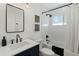 Modern bathroom with a navy vanity, white herringbone tile, black fixtures, and a bathtub with shower at 4595 E Calle Redonda --, Phoenix, AZ 85018