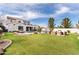 Expansive backyard featuring lush grass, a swimming pool, patio lounge area, and a cozy outdoor firepit at 5139 S Bridal Vail Dr, Gilbert, AZ 85298