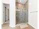 Tiled shower stall with a glass door and a neutral-colored tiled wall at 5139 S Bridal Vail Dr, Gilbert, AZ 85298