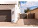 View of the side of a home with a dark-stained garage door and a private walkway leading to a backyard gate at 5139 S Bridal Vail Dr, Gilbert, AZ 85298