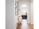 Hallway featuring a decorative bench, framed photos, and access to the laundry room at 5139 S Bridal Vail Dr, Gilbert, AZ 85298