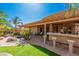 Inviting outdoor space featuring a covered patio, outdoor kitchen and a serene pond feature at 5161 N Scottsdale Rd, Eloy, AZ 85131