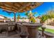 Outdoor kitchen area with gas grill, bar seating, and stone countertops at 5161 N Scottsdale Rd, Eloy, AZ 85131