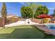 Beautiful backyard with a putting green, pizza oven, pool and well-maintained landscaping at 5356 W Jupiter Way, Chandler, AZ 85226