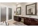 Bathroom features dual sinks, dark wood cabinets, and large mirrors at 5356 W Jupiter Way, Chandler, AZ 85226