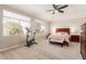 Bright bedroom showcasing a ceiling fan, two large windows, carpeted floor, and comfortable furniture at 5356 W Jupiter Way, Chandler, AZ 85226