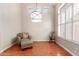 Cozy living room featuring a leather armchair with ottoman, modern lighting fixture, and shuttered windows at 5356 W Jupiter Way, Chandler, AZ 85226