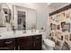 This bathroom has a decorative shower curtain, brown vanity, framed mirror and neutral walls at 5539 S Verde --, Mesa, AZ 85212