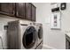 Complete laundry room with stainless steel washer and dryer and dark wood cabinets at 5539 S Verde --, Mesa, AZ 85212