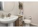 Well-lit powder room featuring a pedestal sink, decorative accents, and a modern toilet at 5539 S Verde --, Mesa, AZ 85212