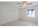 This bedroom features tile flooring, white walls and a ceiling fan with light fixture at 625 W Central Ave, Coolidge, AZ 85128