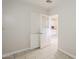 Hallway with tiled floors leading to a kitchen with white cabinets, offering a glimpse into the home's layout at 625 W Central Ave, Coolidge, AZ 85128