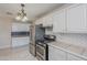 Bright kitchen with stainless steel appliances, tile countertops, gas range, and stylish light fixture at 625 W Central Ave, Coolidge, AZ 85128