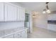 Bright kitchen boasts white cabinets, tile countertops, and backsplash, offering a clean, modern aesthetic at 625 W Central Ave, Coolidge, AZ 85128