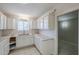 Well-lit kitchen featuring white cabinetry, tile countertops, stainless steel sink, and ample storage space at 625 W Central Ave, Coolidge, AZ 85128