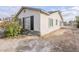 Side view of a charming home featuring a stucco exterior, black shutters, stone accents, and a spacious yard at 625 W Central Ave, Coolidge, AZ 85128