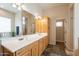 Bathroom with double sinks, wood cabinets, large mirror, and tile flooring at 6786 W Appaloosa Trl, Coolidge, AZ 85128