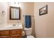 Charming powder room featuring a wooden vanity with a modern mirror and neutral decor at 6786 W Appaloosa Trl, Coolidge, AZ 85128