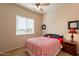 Serene bedroom featuring a comfortable bed with a red and white quilt and bedside table at 6786 W Appaloosa Trl, Coolidge, AZ 85128