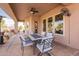 Covered patio with a dining table set, ceiling fan, and views of the landscaped backyard at 6786 W Appaloosa Trl, Coolidge, AZ 85128