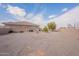 Exterior of tan stucco single-story home featuring spacious gravel side yard at 6786 W Appaloosa Trl, Coolidge, AZ 85128