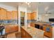 Bright kitchen featuring wooden cabinets, granite counters, backsplash and walk-in pantry at 6786 W Appaloosa Trl, Coolidge, AZ 85128