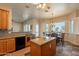 Bright kitchen featuring wooden cabinets, granite counters, breakfast bar, and tile backsplash at 6786 W Appaloosa Trl, Coolidge, AZ 85128