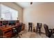 Well-organized home office with custom desk, chairs, and ample natural light at 6786 W Appaloosa Trl, Coolidge, AZ 85128