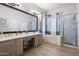 Beautiful bathroom featuring double sinks, soaking tub, vanity, and a glass enclosed shower at 6890 W Remuda Dr, Peoria, AZ 85383