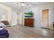 Bright main bedroom with wood floors, ceiling fan, large television, and door to the patio at 6890 W Remuda Dr, Peoria, AZ 85383