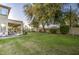 Large backyard featuring a covered patio with seating and a lush green lawn at 7010 S San Jacinto Ct, Gilbert, AZ 85298