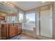 Bright bathroom featuring a bathtub, shower, vanity with sink, and ample natural light from the window at 7010 S San Jacinto Ct, Gilbert, AZ 85298