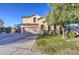 Charming stucco home with a well-manicured lawn, mature tree, and a two-car garage at 7010 S San Jacinto Ct, Gilbert, AZ 85298