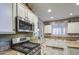 Modern kitchen features stainless steel microwave and gas cooktop along with granite countertops and custom cabinets at 7010 S San Jacinto Ct, Gilbert, AZ 85298